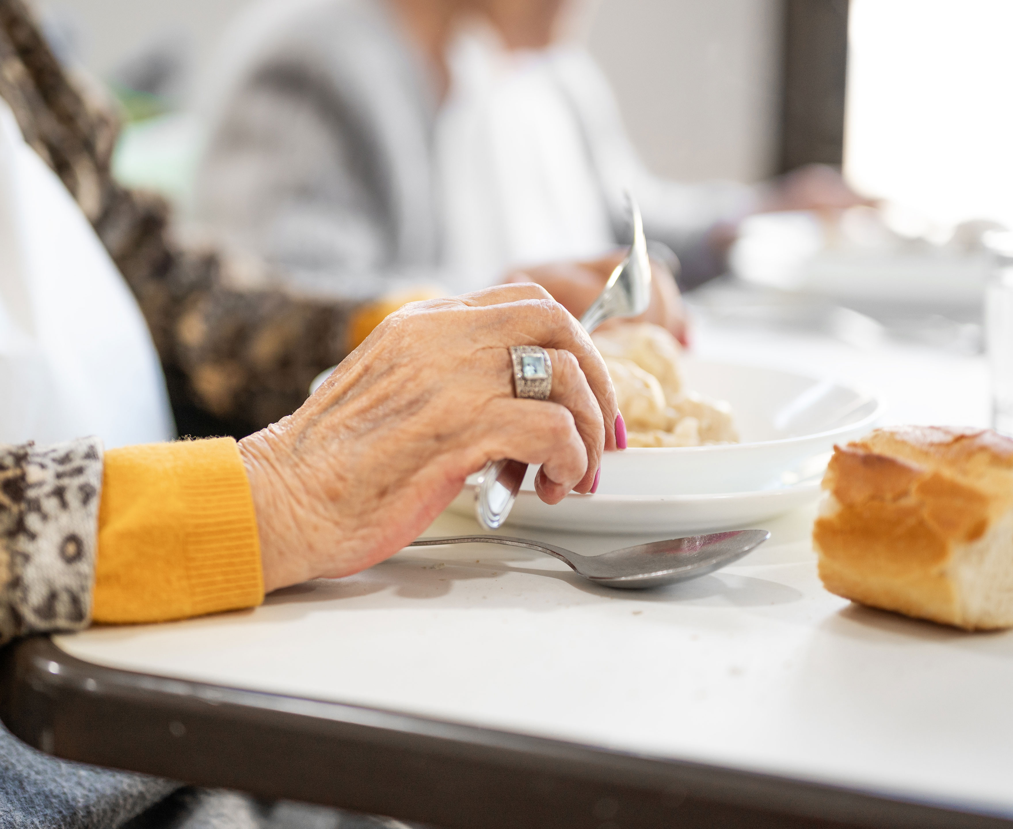 Hånd fra en ælde dame der spiser mad